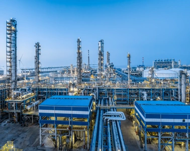 Installation de traitement pétrolier et gazier avec tours de raffinerie et pipelines sous un ciel bleu