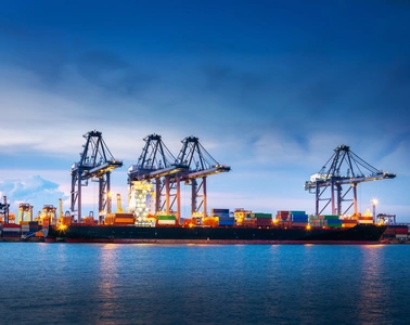 Port à conteneurs avec portiques de quai au crépuscule