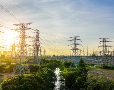 Pylônes de transport haute tension et poste électrique au lever du soleil