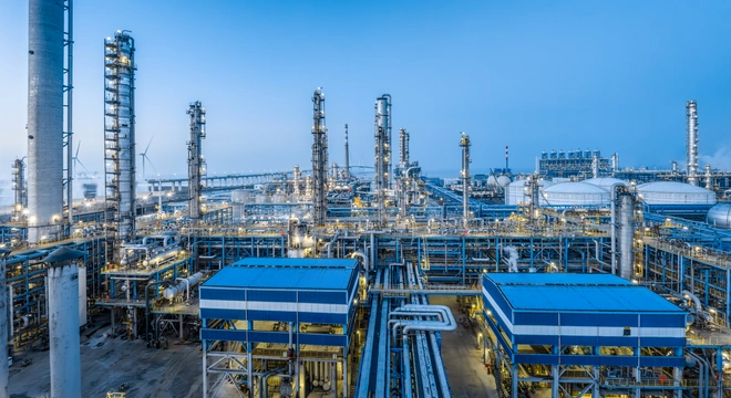 Installation de traitement p&eacute;trolier et gazier avec tours de raffinerie et pipelines sous un ciel bleu