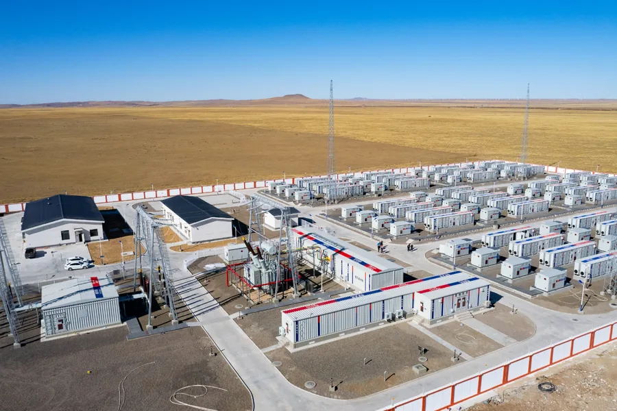 Rangées de modules préfabriqués de stockage par batteries et d'E-House sur un site d'énergies renouvelables en pleine prairie