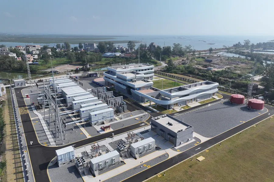 Vue aérienne d'un site industriel côtier avec des E-House modulaires à côté d'un poste extérieur